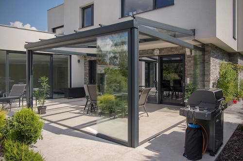 Nezateplená prosklená pergola od PLAS.cz jako elegantní rozšíření terasy, které poskytuje ochranu před větrem a komfortní venkovní posezení.