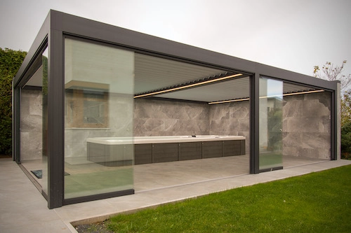 Bioklimatická pergola Renson od PLAS.cz s prosklenými stěnami a vestavěnou vířivkou, která poskyuje luxusní relaxaci v soukromí zahrady.