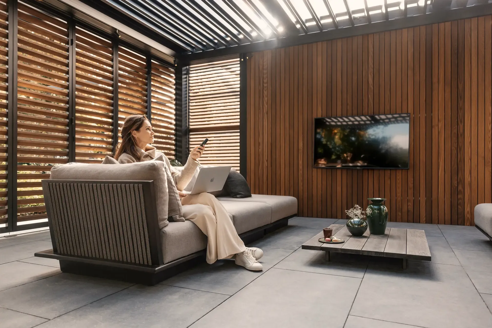 Bioklimatická pergola Renson od PLAS.cz umístěná u bazénu, která poskytuje elegantní stíněné posezení v přírodním prostředí.