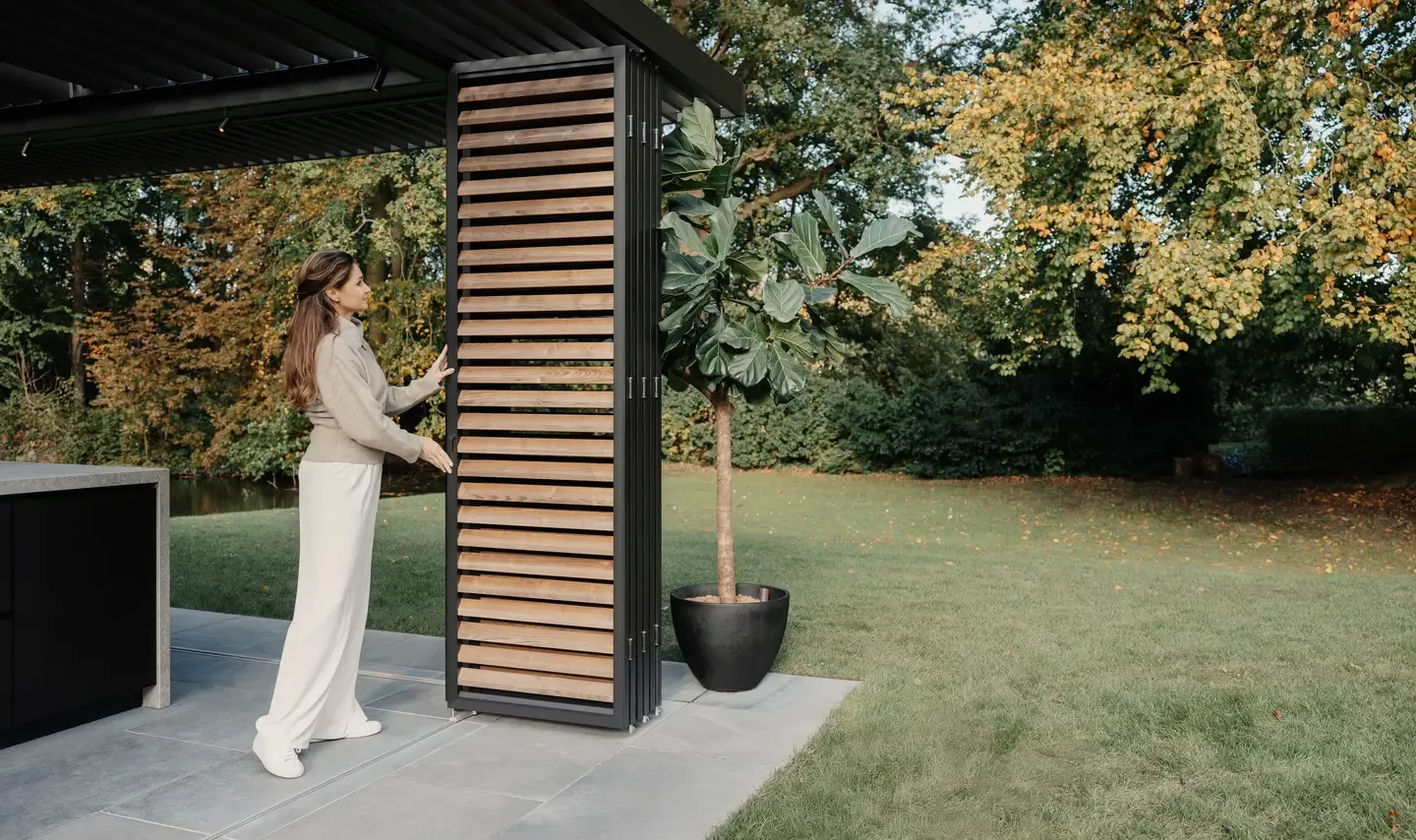 Bioklimatická pergola Renson od PLAS.cz elegantně ladící s cihlovým domem, která poskytuje stín a komfortní posezení na terase.